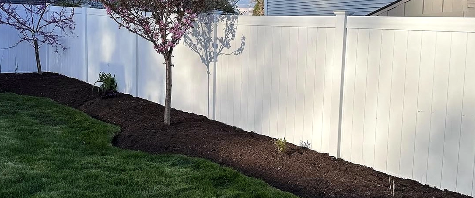 Freshly mulched garden bed with crisp edging against a striped lawn